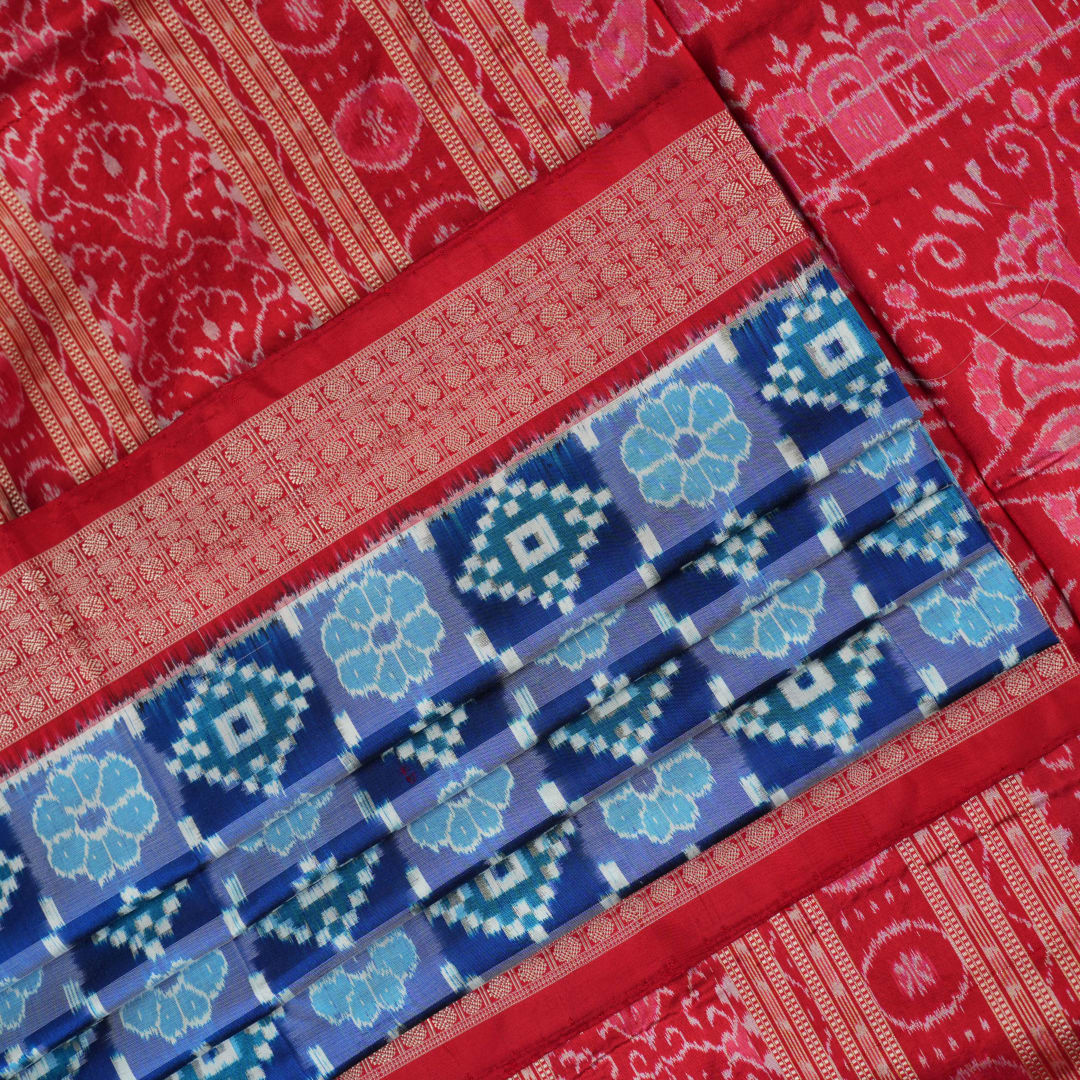 Close-up of the luxurious silk fabric texture and distinctive Sambalpuri ikat weave of the blue Pasapalli saree.