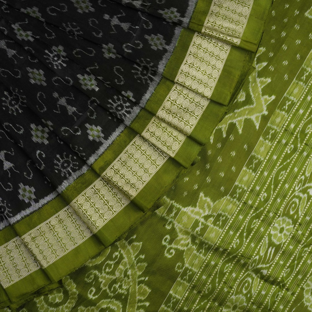 Close-up of the luxurious black and green Sambalpuri silk fabric texture and weave.