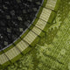 Close-up of the luxurious black and green Sambalpuri silk fabric texture and weave.
