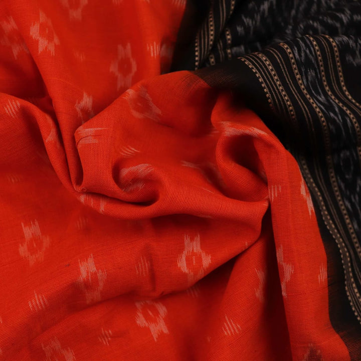 Full body view of a folded Sambalpuri cotton dupatta in orange with bold black motifs.