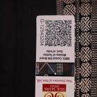 Close-up of magenta and black Bomkai silk saree texture, showing butta pattern weave.