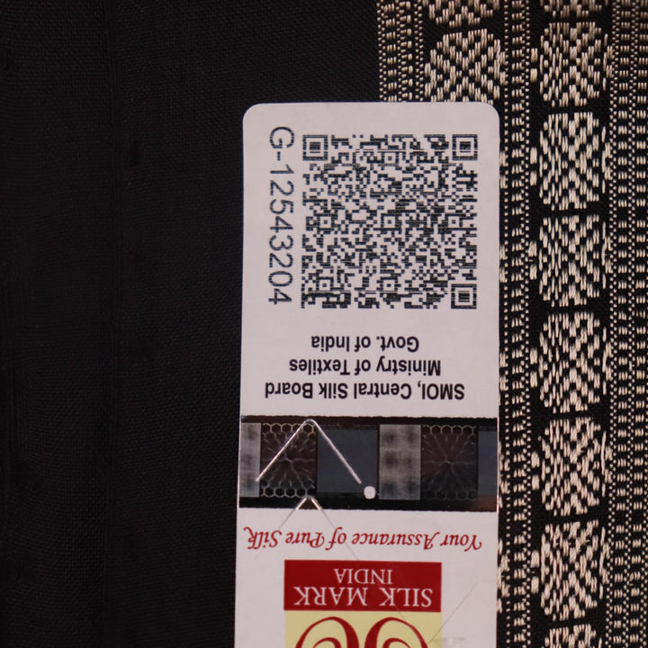 Close-up of magenta and black Bomkai silk saree texture, showing butta pattern weave.