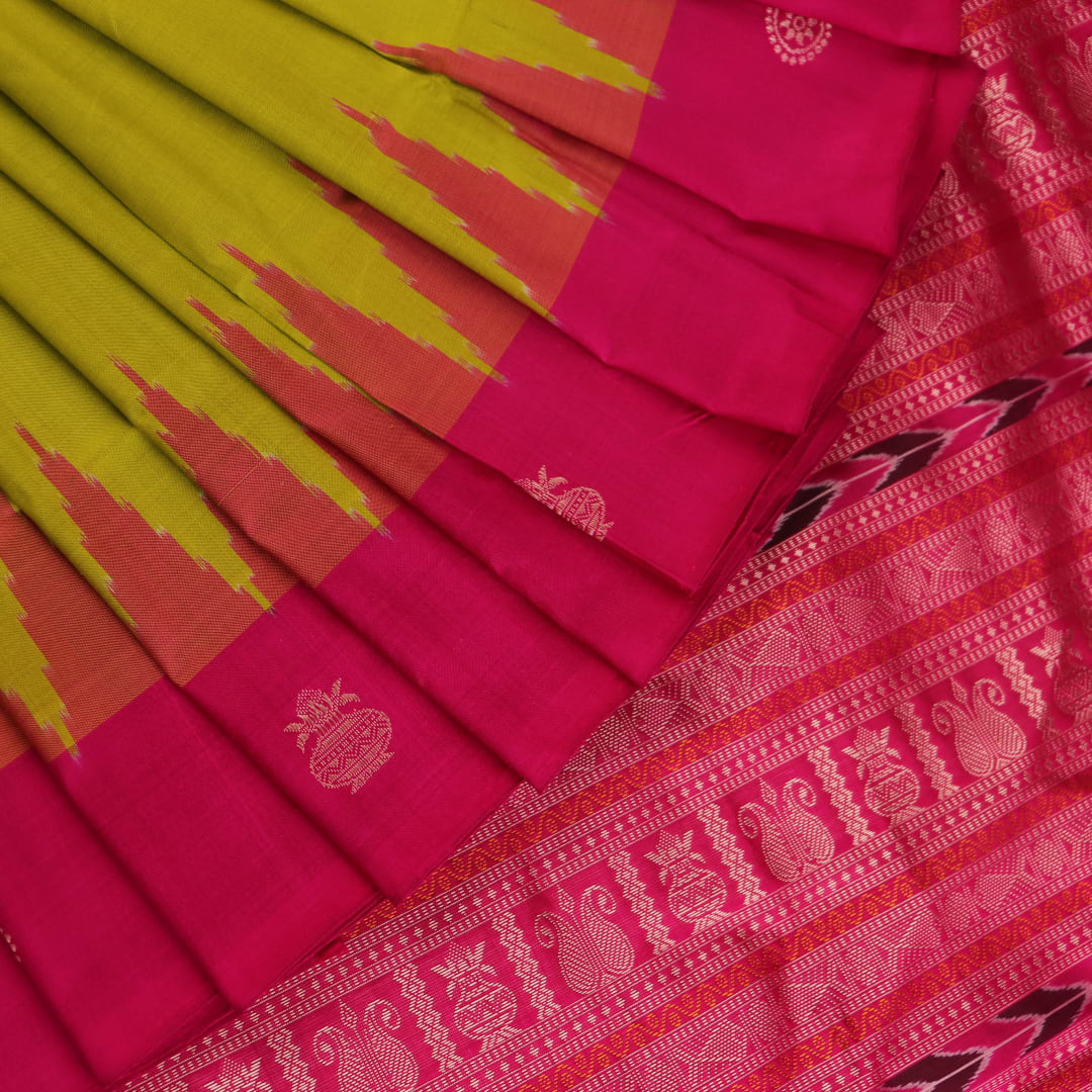 Close-up of green and magenta Bomkai silk saree fabric texture, highlighting intricate weave and butta pattern.
