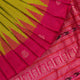 Close-up of green and magenta Bomkai silk saree fabric texture, highlighting intricate weave and butta pattern.
