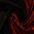 Draping view of a black Khandua silk saree with a red border and butta pattern