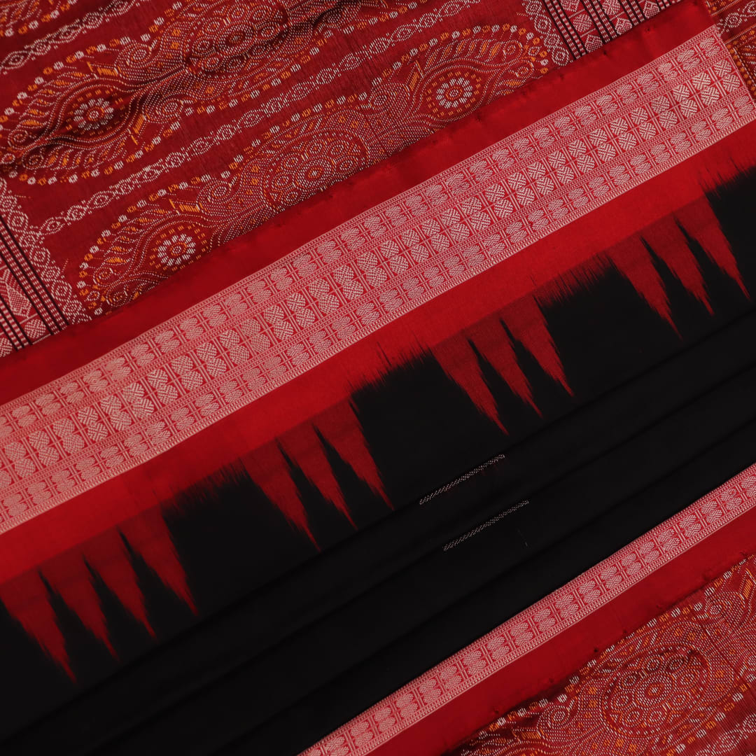 Close-up of black and red silk Sambalpuri saree fabric showcasing intricate motifs