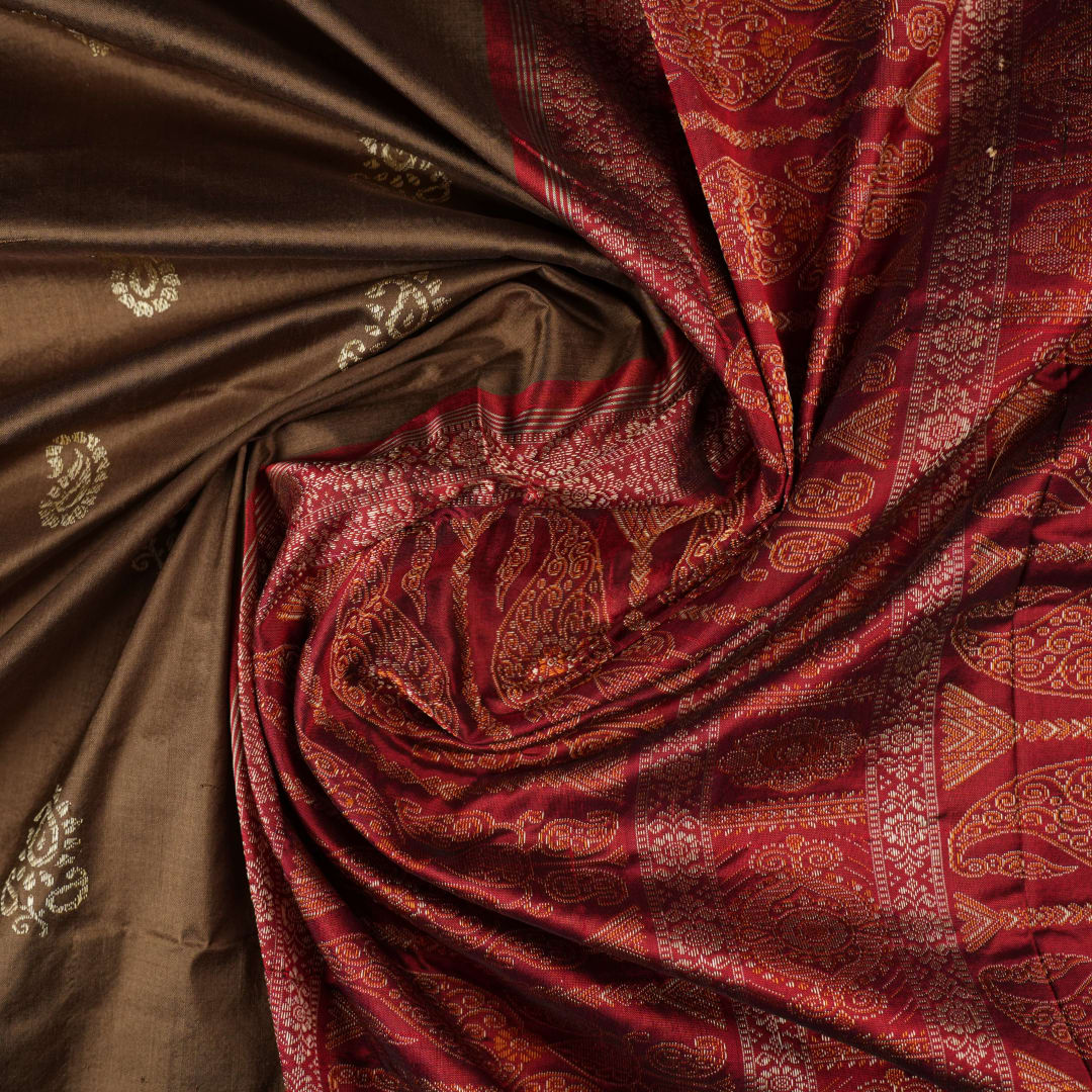 Close-up of Bomkai Silk Saree fabric, highlighting its luxurious brown silk texture and intricate weave.