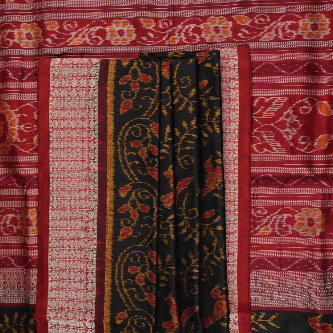 Close-up of Sambalpuri silk fabric texture, highlighting fine handloom weave in black and maroon.
