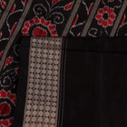 Close-up of red and black silk Sambalpuri saree fabric with intricate motifs
