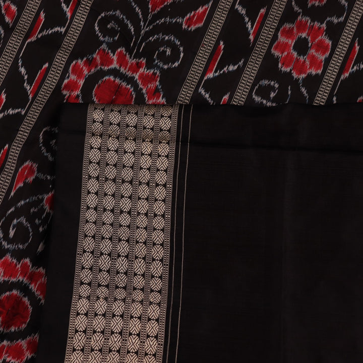 Close-up of red and black silk Sambalpuri saree fabric with intricate motifs