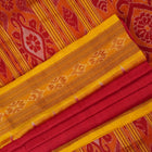 Model draped in a red and yellow Khandua silk saree with butta patterns for a traditional look.
