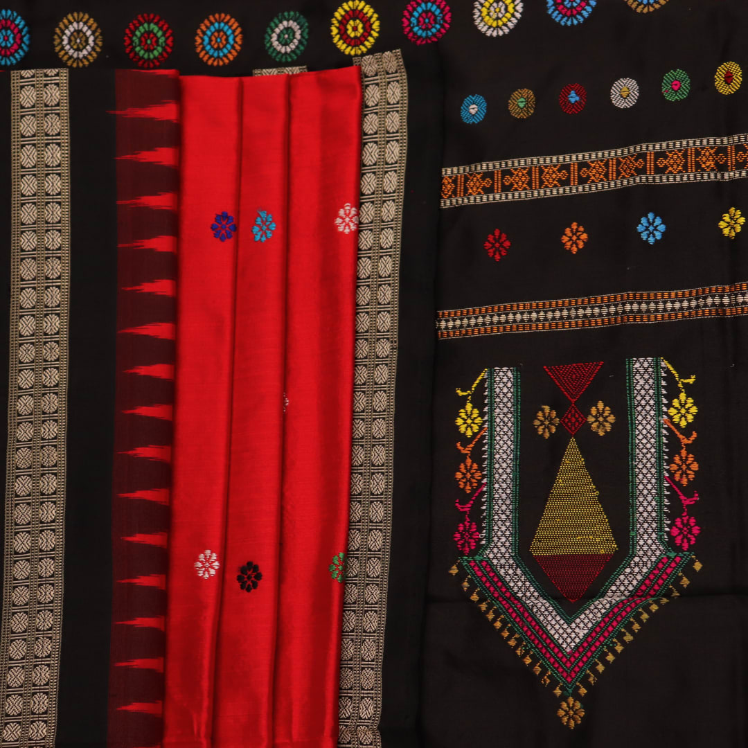 Close-up view of the soft and lustrous silk fabric texture of a Dolabedi red and black handloom saree with a butta pattern.