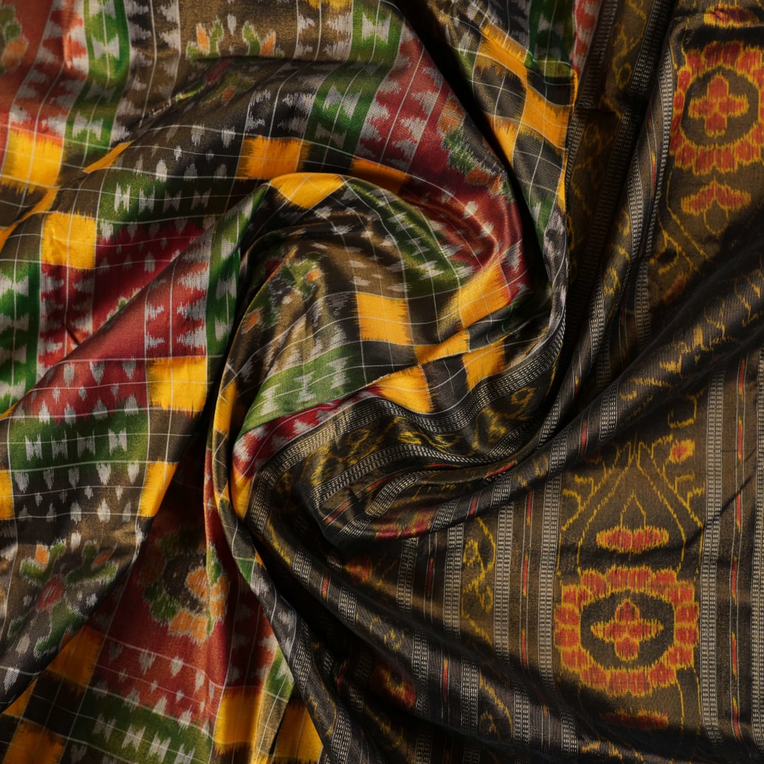 Extreme close-up of Sambalpuri Silk Saree fabric, revealing multi-color brown weave and tissue texture.