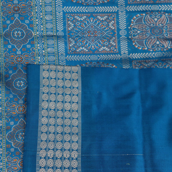 Close-up of Bomkai silk saree's textured weave, featuring magenta, blue, and butta pattern.
