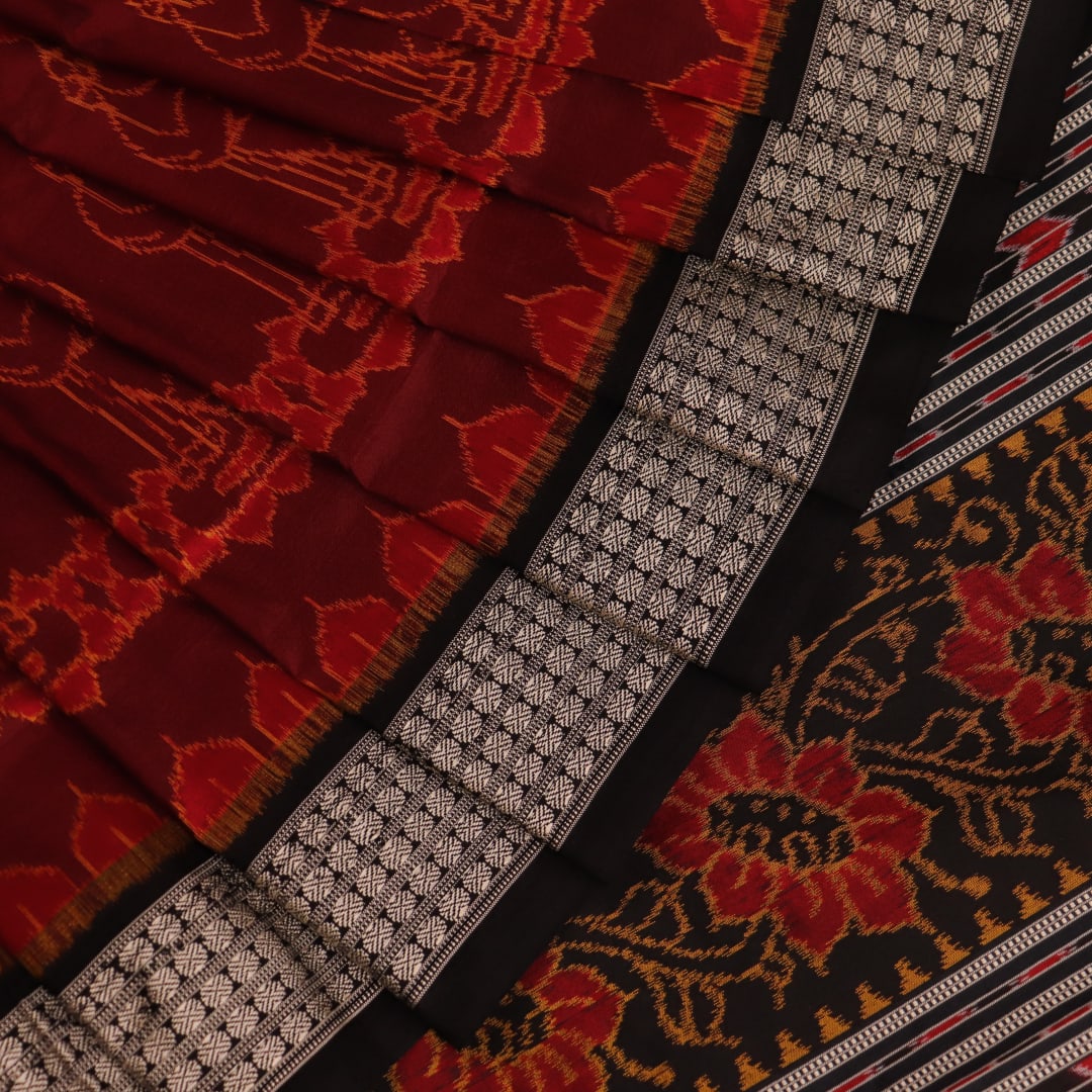 Close-up of intricate motifs on a maroon Sambalpuri silk saree