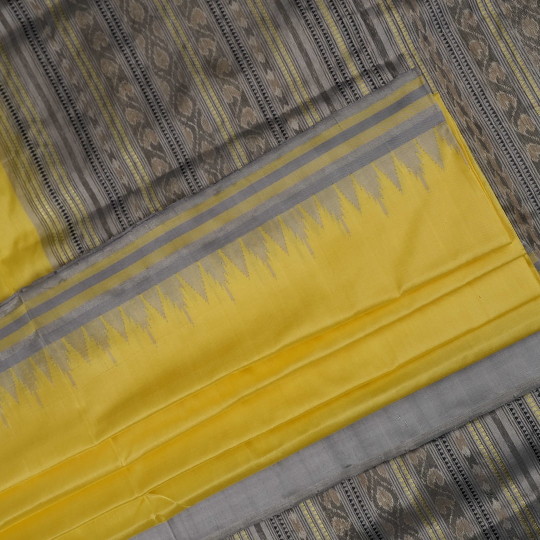 Close-up of the luxurious yellow Sambalpuri silk fabric, showing its fine weave and texture.