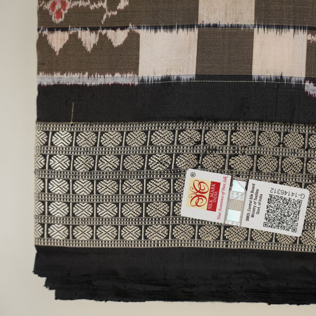 Close-up of the luxurious silk fabric texture and handloom weave of the grey and black Sambalpuri saree.