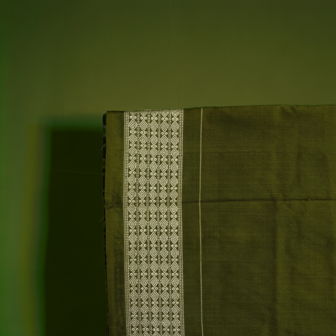 Close-up of the luxurious texture of the white Sambalpuri Silk Saree, revealing the fine weave and motif details.