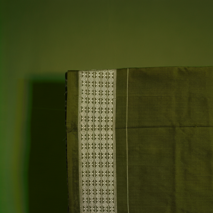 Close-up of the luxurious texture of the white Sambalpuri Silk Saree, revealing the fine weave and motif details.