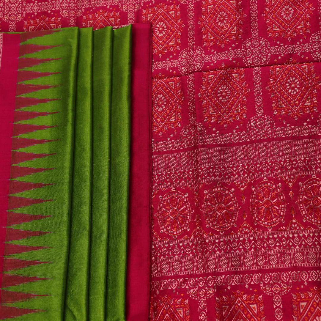 Textured close-up of green Bomkai silk saree fabric, revealing intricate weave and magenta butta pattern.
