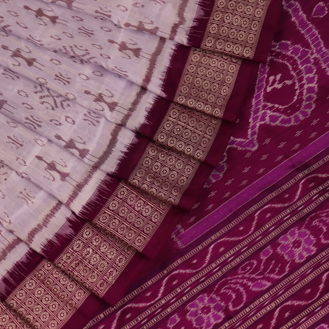 Close-up of silk fabric with intricate Sambalpuri motif design in multicolor and purple hues