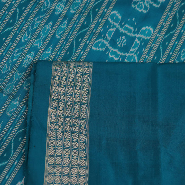 Close-up showcasing the purple and blue silk fabric texture of the Sambalpuri saree with intricate motifs.