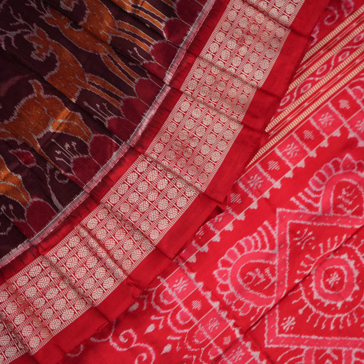 Close-up of the maroon Sambalpuri silk saree fabric, highlighting its luxurious texture and intricate weave.