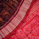 Close-up of the maroon Sambalpuri silk saree fabric, highlighting its luxurious texture and intricate weave.