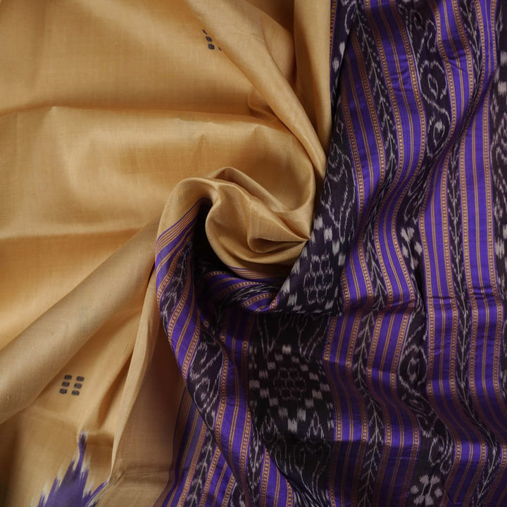 Model draped in a cream and blue Khandua silk saree with butta patterns, showcasing traditional styling.