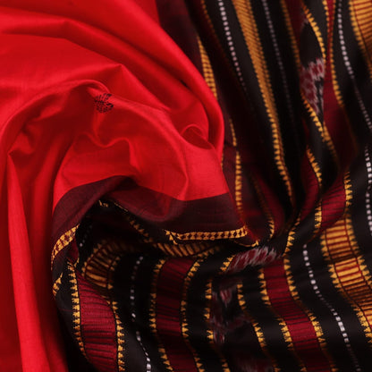 Textured close-up of red and black Sambalpuri Silk Saree fabric, highlighting the woven butta pattern.