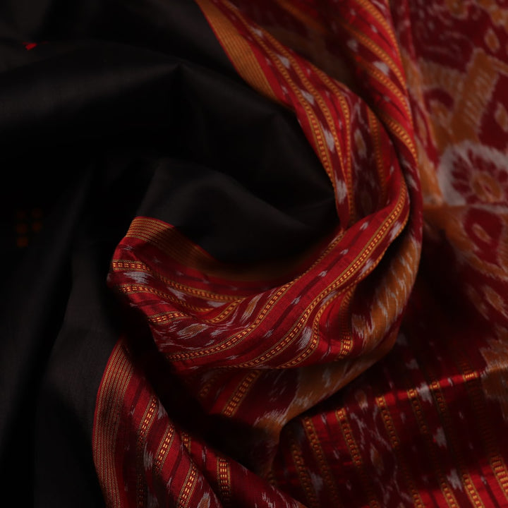 Black Khandua silk saree styled; showcases the drape and overall appearance, highlighting the red butta pattern.
