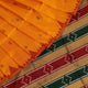 Close-up of yellow & green Sambalpuri Silk Saree fabric texture, showing Butta pattern.