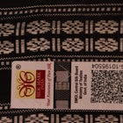 A close-up view of the lush, green silk fabric with a black butta pattern woven in.