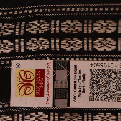 A close-up view of the lush, green silk fabric with a black butta pattern woven in.