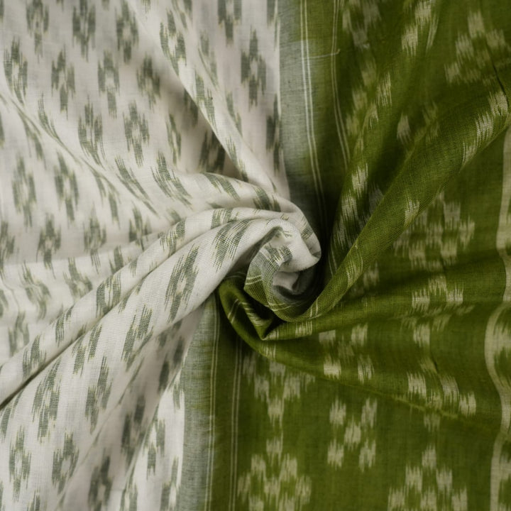 Model wearing a white and green Sambalpuri cotton saree, demonstrating the elegant drape and handloom motifs.