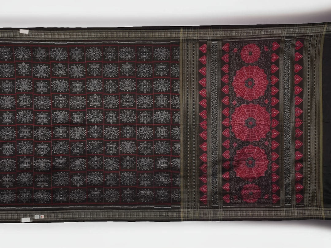 Extreme close-up of black Sambalpuri silk saree fabric, highlighting its luxurious texture and weave.