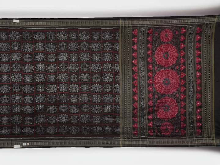 Extreme close-up of black Sambalpuri silk saree fabric, highlighting its luxurious texture and weave.