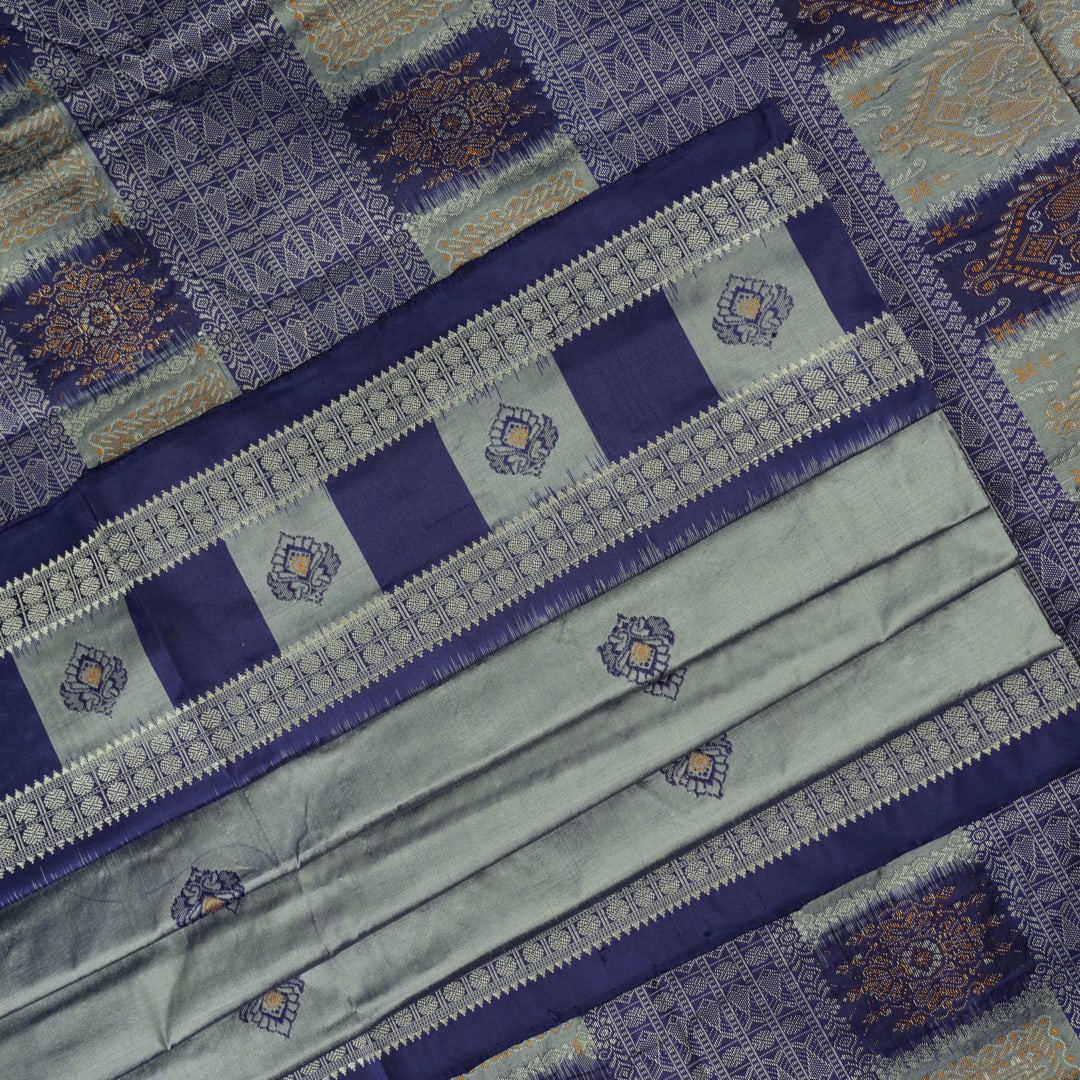 Close-up of luxurious Bomkai Silk Saree fabric texture, highlighting grey and blue handloom weave.