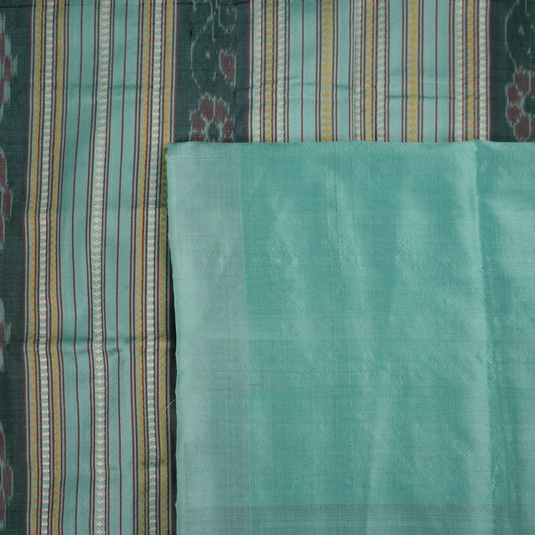 Extreme close-up of the green Sambalpuri silk fabric, revealing its luxurious texture and fine handloom weave.