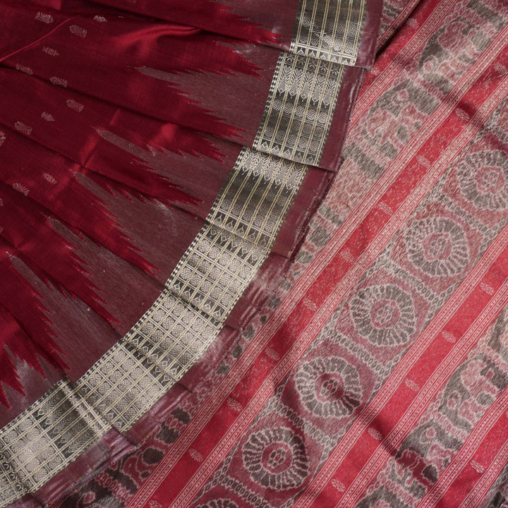 Extreme close-up revealing the rich texture and intricate handloom weave of the maroon and grey Sambalpuri silk fabric.