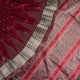Extreme close-up revealing the rich texture and intricate handloom weave of the maroon and grey Sambalpuri silk fabric.