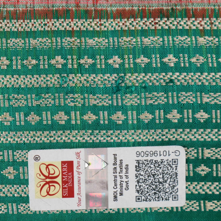 Extreme close-up of the rich orange Sambalpuri silk fabric, highlighting its intricate handloom weave texture.