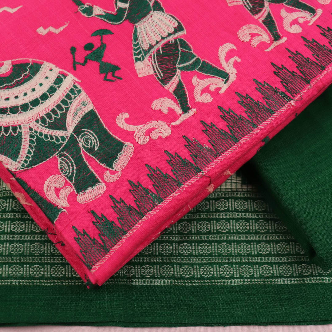 Close-up of the green and pink fabric texture of a Sambalpuri cotton dress material, featuring a repeating doll pattern.