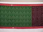 Model draped in a green and red Sambalpuri cotton saree with traditional motifs, styled for a classic look.