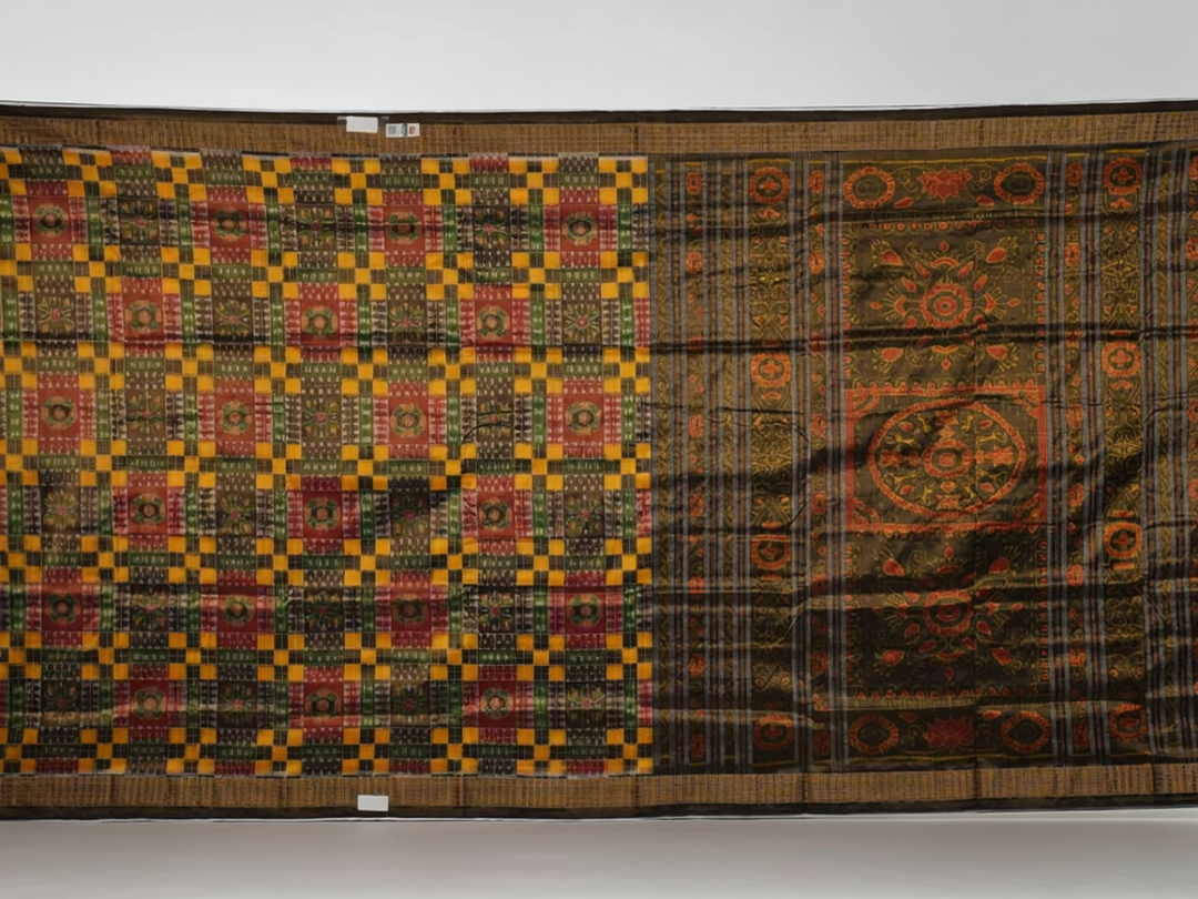 Extreme close-up of Sambalpuri Silk Saree fabric, revealing multi-color brown weave and tissue texture.