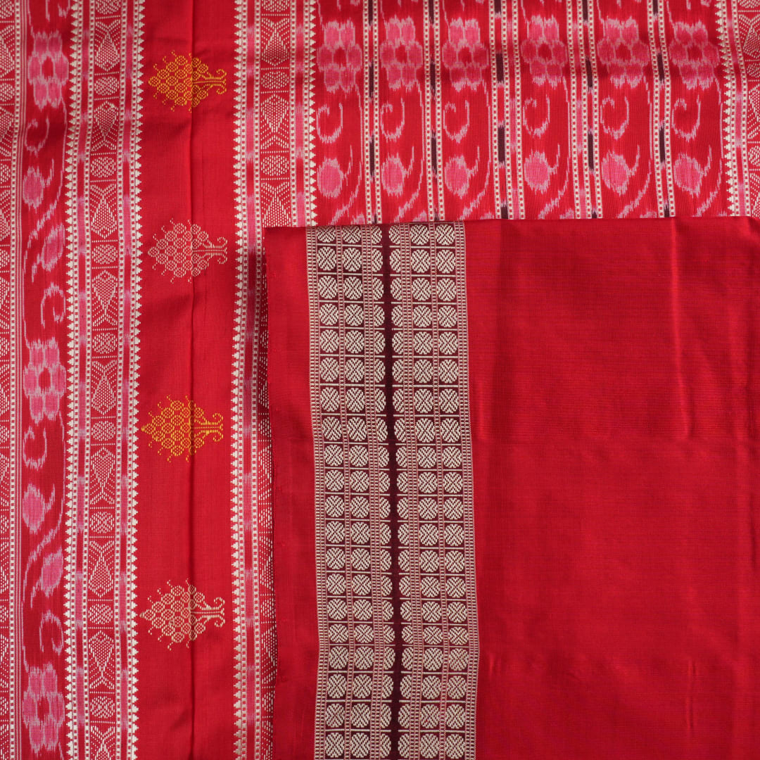 Extreme close-up revealing the rich Bomkai silk fabric texture and intricate handloom weave details in white and red.