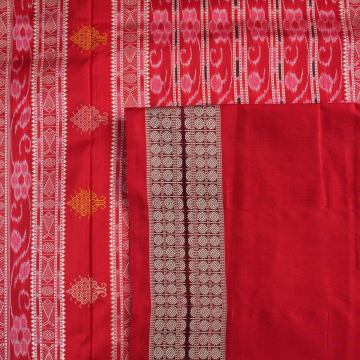Extreme close-up revealing the rich Bomkai silk fabric texture and intricate handloom weave details in white and red.