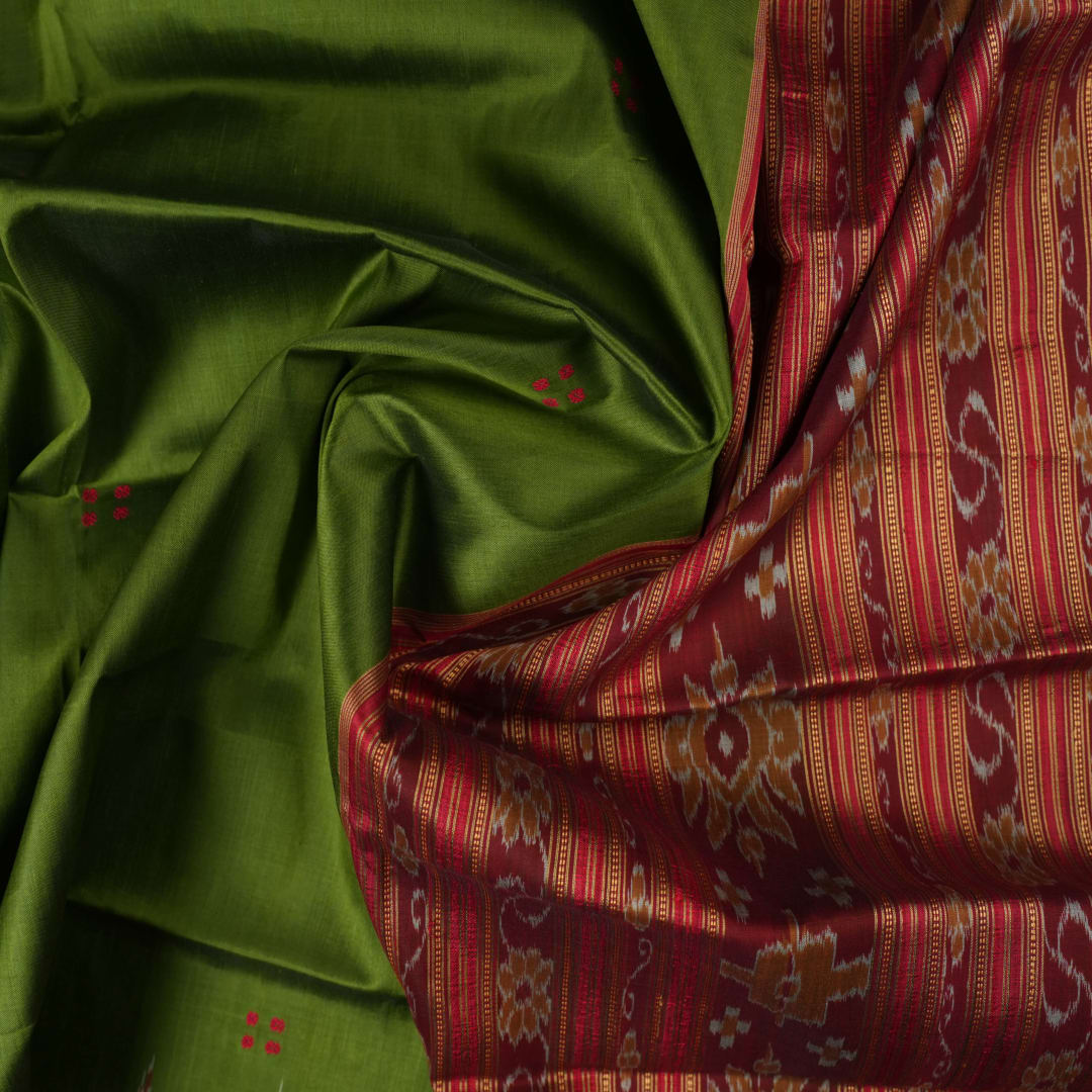 Model draped in a green and red Khandua silk saree with traditional butta work and rich border.