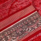 Close-up of grey Sambalpuri silk saree fabric showing intricate motif texture.