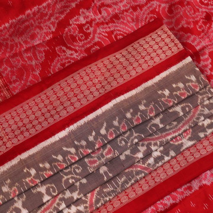 Close-up of grey Sambalpuri silk saree fabric showing intricate motif texture.